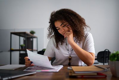 Mujer revisando notificaciones y documentos de una Sección de Desnaturalización Mujer revisando notificaciones y documentos de una Sección de Desnaturalización